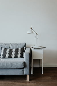 white task light on white side table beside blue sofa thumbnail