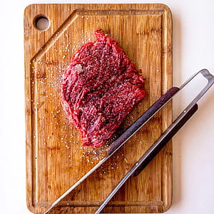 Brown Wooden Chopping Board With Meat On Top thumbnail