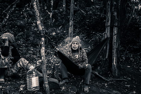 grayscale photo of person sitting on hammock thumbnail