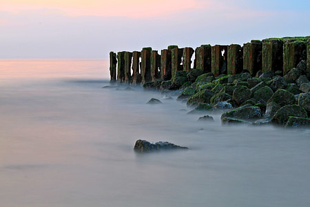 landscape photography of a standing stones on body of water thumbnail