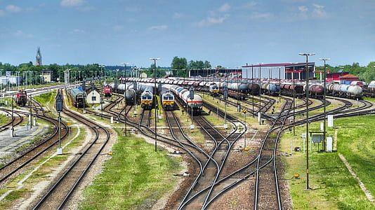 assorted-colors trains under clear blue sky during daytime thumbnail