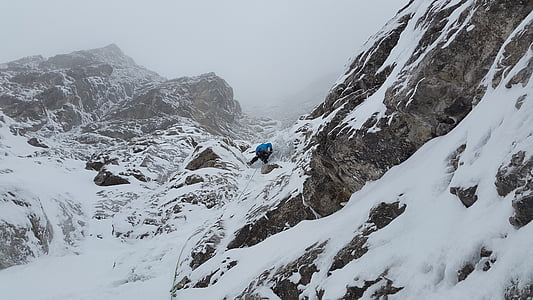 person climbing the mountain covered with snow thumbnail