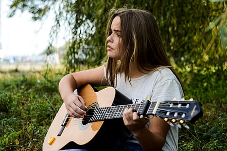 woman in white shirt playing guitar thumbnail