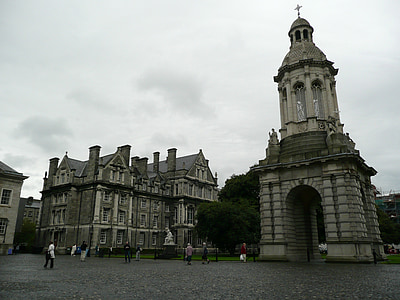 gray tower beside buildings under cloudy day sky thumbnail