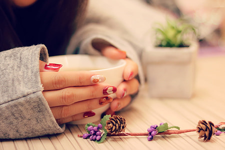 woman holding white ceramic cup thumbnail