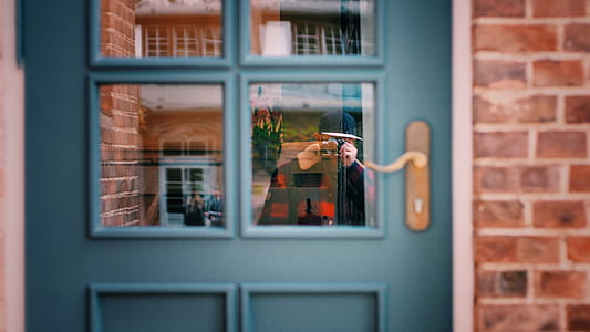 Man in Black Sweater Taking Photo of Blue Door thumbnail