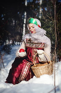 woman sitting on snow holding red apple thumbnail