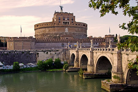 stone wall bridge near tree and building thumbnail
