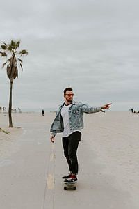 man riding on skateboard on road thumbnail