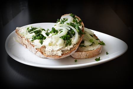 bread topped with vegetables and sliced onions on white plate thumbnail