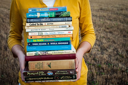 person in yellow shirt carrying books thumbnail