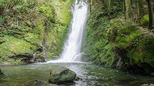 photo of falls in between rock formation covered of moss thumbnail
