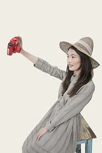 woman holding red camera thumbnail