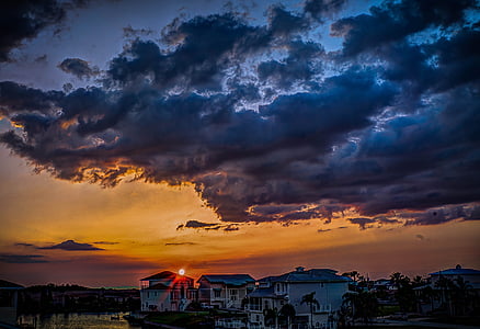 white wooden house under ray clouds thumbnail