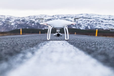 white drone on concrete road thumbnail