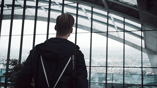 man standing beside window grills thumbnail