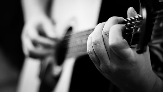 grayscale photography of person with guitar thumbnail