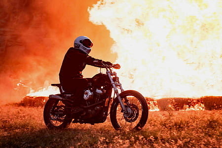 person riding motorcycle near burning area thumbnail