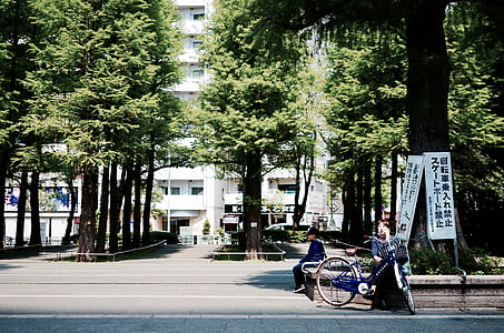 man sitting on gray pavement road thumbnail