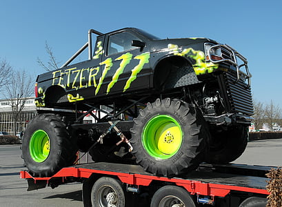 black and green Fetzer monster truck on trailer during daytime thumbnail
