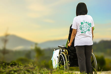 woman in white t-shirt holding black self-propelled wheelchair thumbnail