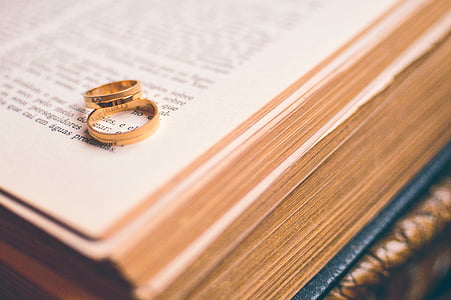 two gold-colored rings on open book thumbnail