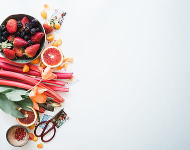 strawberry fruits beside orange petaled flower on white surface thumbnail