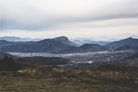 green grass field with mountain range in background thumbnail
