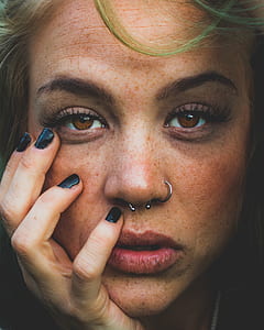 close-up photography of woman holding her right cheek thumbnail