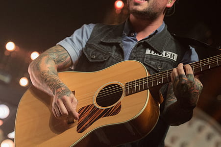 man playing brown acoustic guitar thumbnail