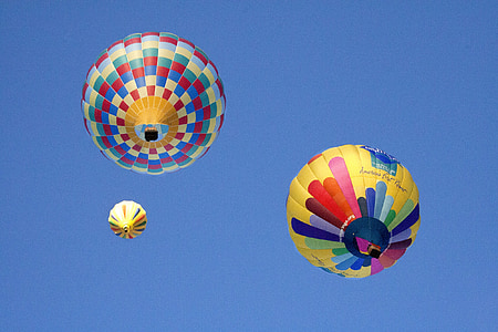 three assorted-color hot-air balloons under blue sky thumbnail