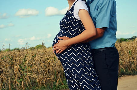 man hugging pregnant wife beside corn fields thumbnail