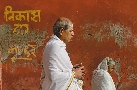man wearing white robe walking on street thumbnail