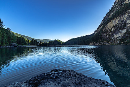 gray rock cliff across calm body of water thumbnail