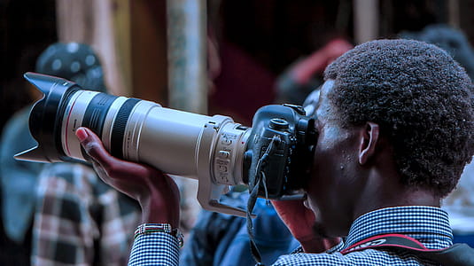 Man Using Black Dslr Camera With White and Black Zoom Lens Outdoor thumbnail