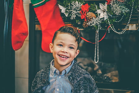 portrait photo of boy standing near window and Christmas stockings thumbnail