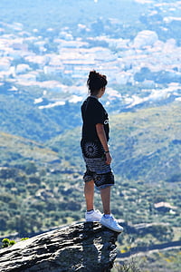 black haired woman in black top and shorts on mountain cliff during day time thumbnail
