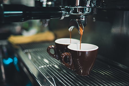 closeup photo of espresso machine pouring coffee in mugs thumbnail