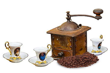 three gold-and-white teacups and saucer with brown manual coffee grinder thumbnail