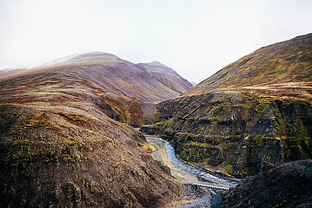 A fresh water stream through the rocky hills covered with clouds thumbnail