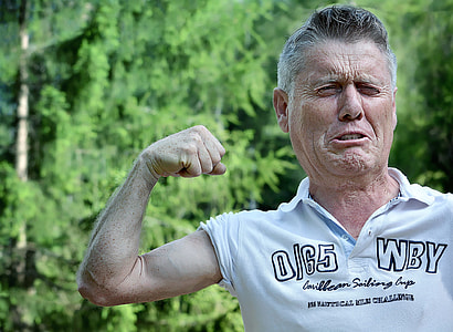 man in white polo shirt showing right bicep thumbnail