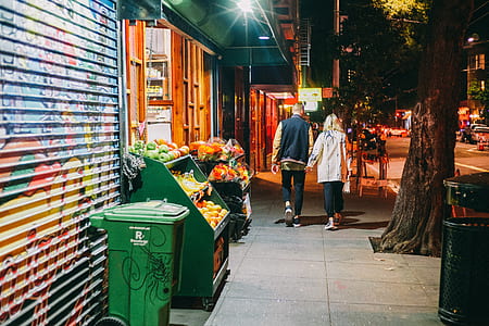 green plastic garbage bin leaning on blue and yellow graffiti print roller shutter thumbnail