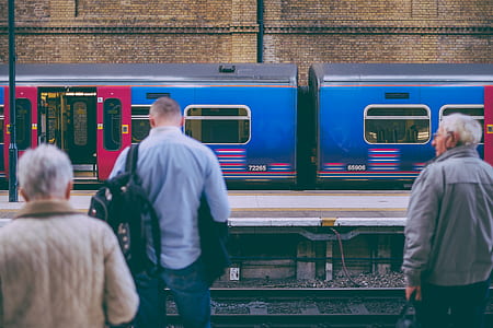 three persons standing beside train thumbnail