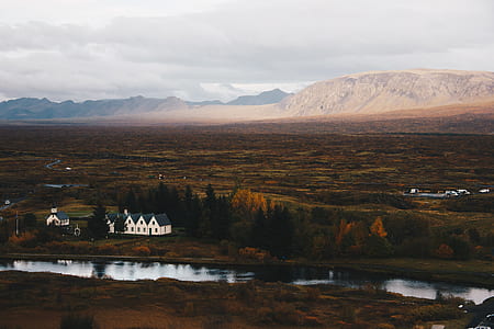 white and blue house near tree across mountain thumbnail