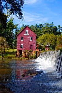 red wooden 2-story house beside river at daytime thumbnail