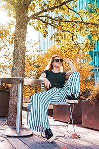 woman sitting on chair under tree during daytime thumbnail