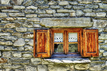 tiny wooden framed window on grey rock wall opened thumbnail