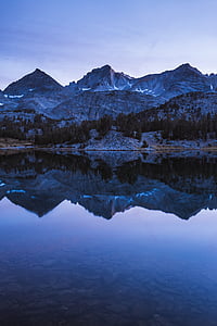 reflective photography of mountain on body of water thumbnail