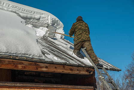 man scraping snow on roof thumbnail