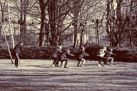 six people squatting beside trees thumbnail